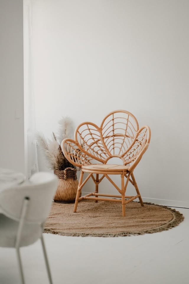Rieten stoel in bloemvorm op een jute vloerkleed